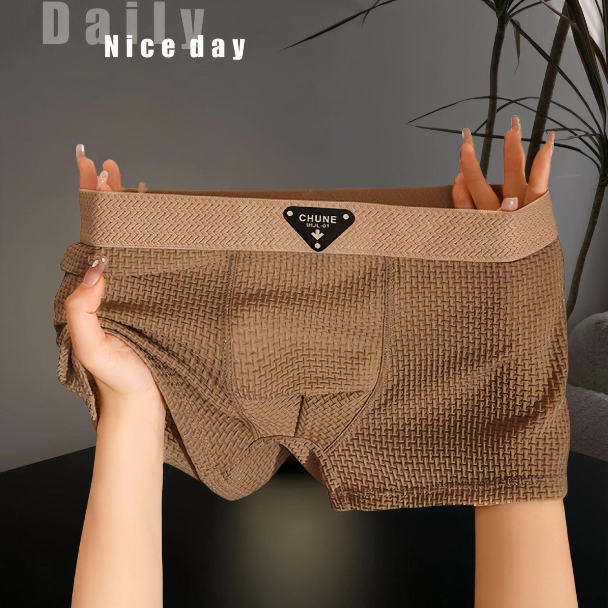 Detail view of brown boxer briefs, highlighting soft fabric and elastic waistband in a studio setting.