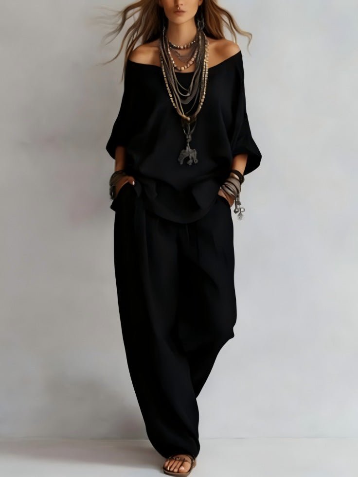 Elegant black off-shoulder outfit featuring three-quarter sleeves and wide-leg pants, perfect for minimalist fashion.