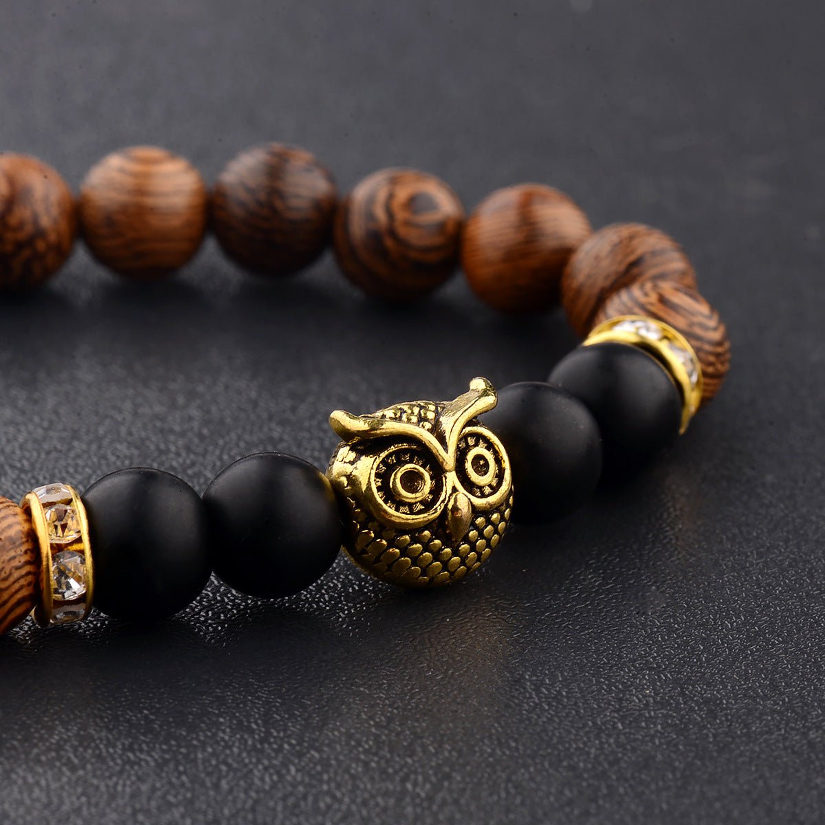Detail close-up of the exotic wood grain bracelet with an owl charm, highlighting its unique beaded design.