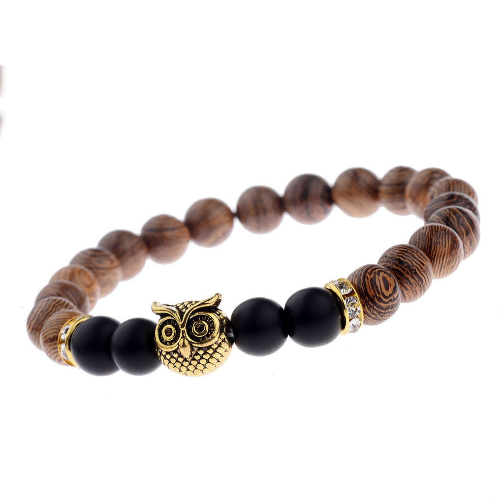 Detail close-up of the exotic wood grain bracelet with an owl charm on a white background, showcasing elegant details.