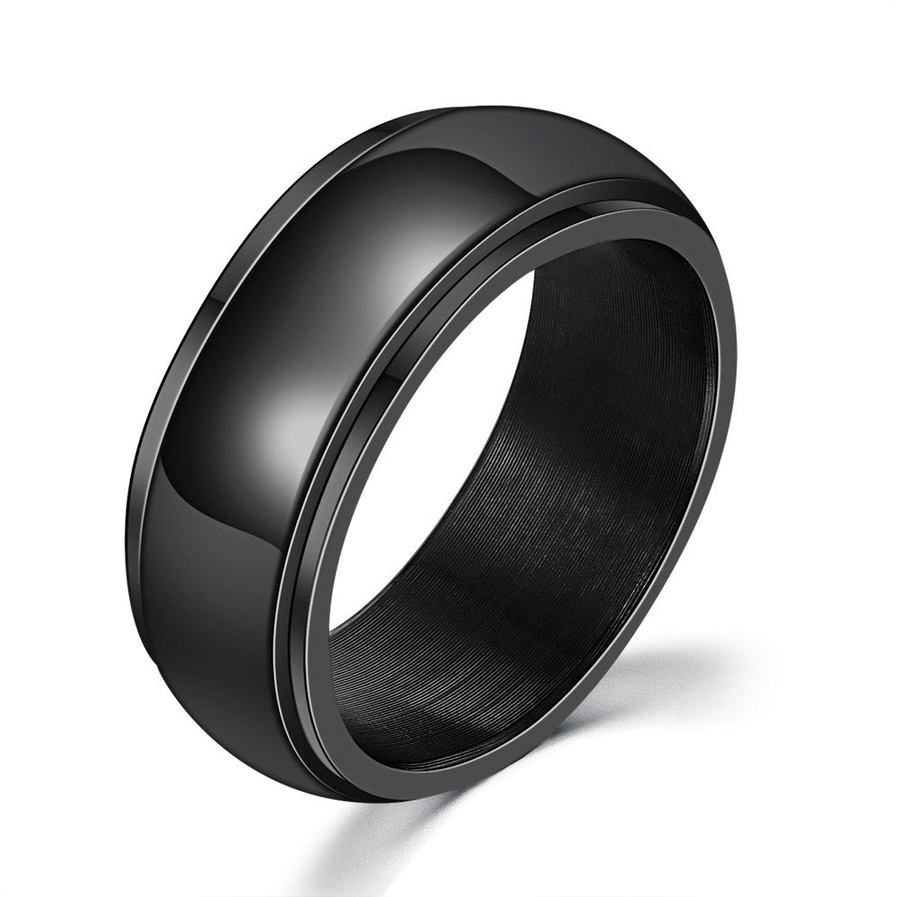 Detail close-up of a plain black titanium steel ring with rounded edges.