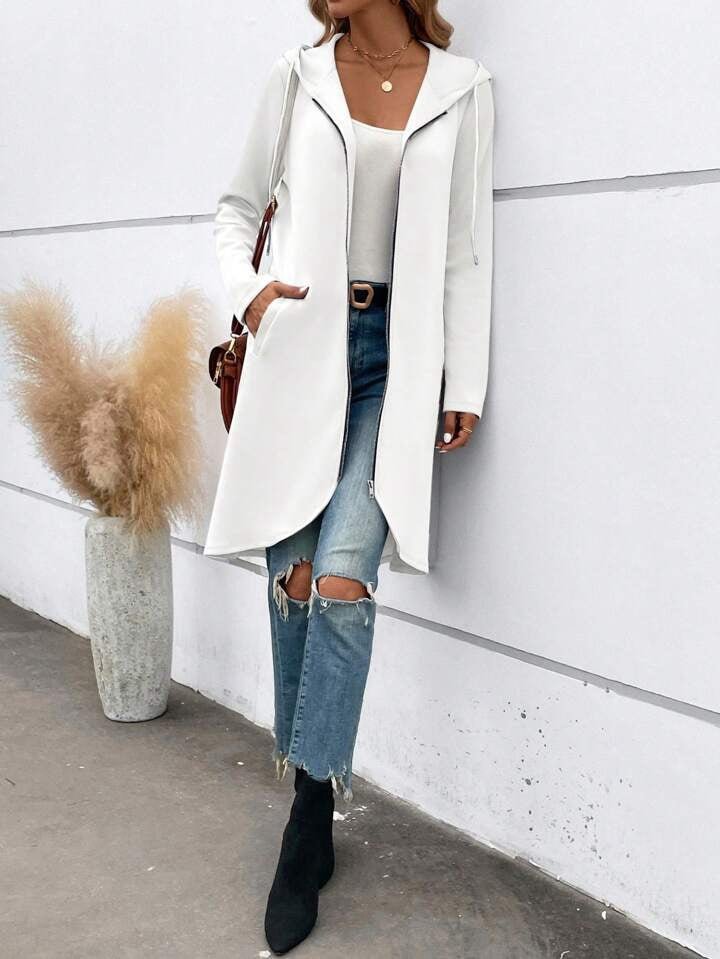 Lifestyle shot of the white zip hooded sweatshirt featuring a long length and velvet lining.
