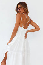 Open back white maxi dress with slit detail, elegantly displayed against a solid background.