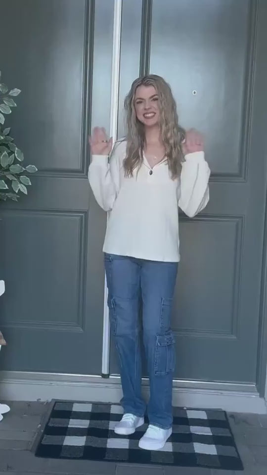 Lifestyle video featuring a woman in a white pullover sweater styled casually.