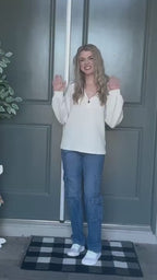 Lifestyle video featuring a woman in a white pullover sweater styled casually.