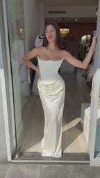 Lifestyle shot of a woman in a white dress with a fitted silhouette, embodying chic minimalist fashion.
