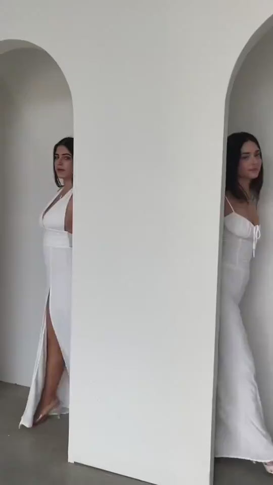 Lifestyle video of a woman in a black dress with a stylish slit design, showcasing chic fashion.