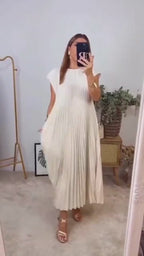 Video showcasing the elegant beige pleated long dress with cap sleeves and flowing design.