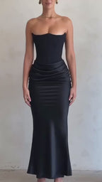 Front view of a woman in a black evening gown with a fitted silhouette, demonstrating elegant chic fashion.