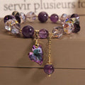 Detail close-up of the purple natural amethyst heart bracelet showcasing heart charm and gold accents.