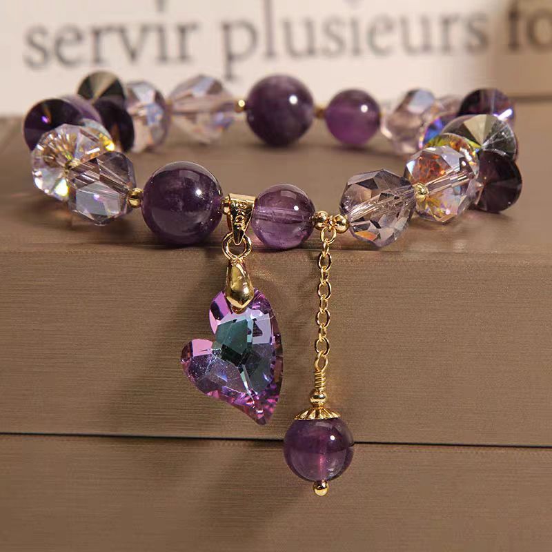 Detail close-up of the purple natural amethyst heart bracelet showcasing heart charm and gold accents.