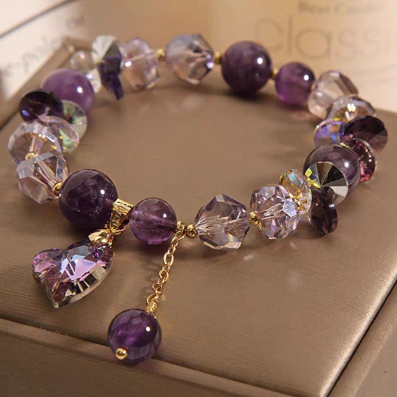 Detail close-up of the purple natural amethyst heart bracelet highlighting gold accents.