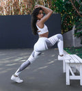 Lifestyle shot of reflective sport yoga pants in white and gray, featuring high waist and stretch fabric.