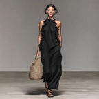 Long black ice silk crepe maxi dress with ruffled halter neck in lifestyle shot, showcasing chic fashion.