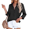 Lifestyle view of a black long sleeve blouse in satin fabric with v-neck and button closure, ideal for chic fashion.