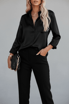 Lifestyle shot of a black satin long sleeve blouse with v-neck, elegant minimalist style for office wear.