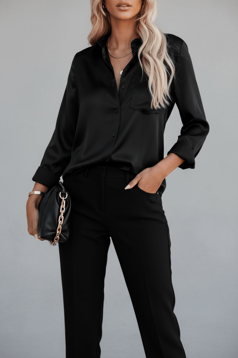 Lifestyle shot of a black satin long sleeve blouse with v-neck, elegant minimalist style for office wear.