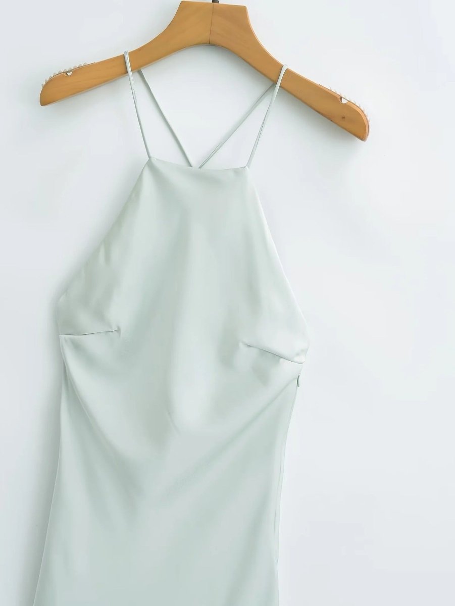 Detail view of the light green satin sling dress, highlighting its spaghetti straps and elegant silk texture.