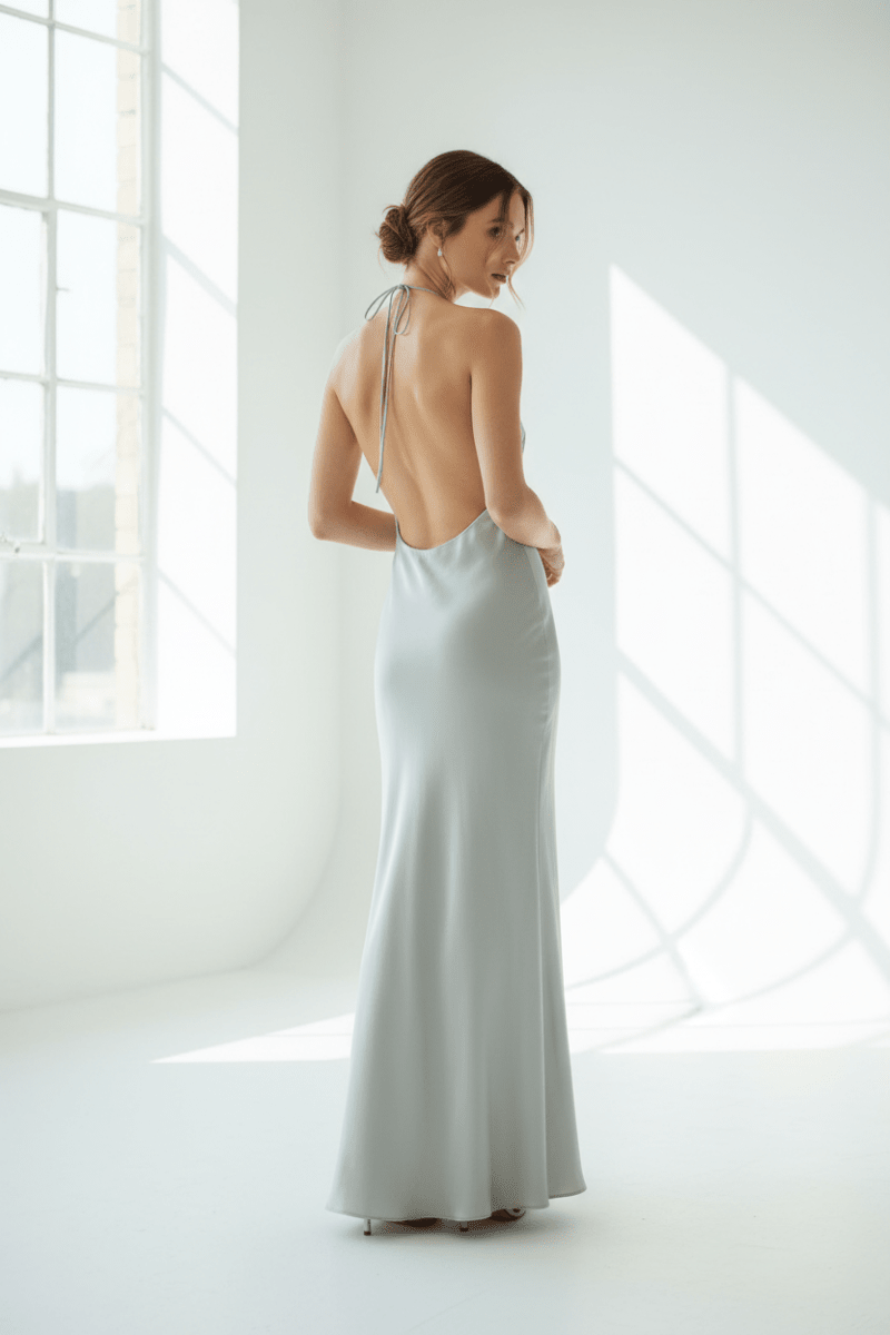 Back view of the silver satin sling dress, featuring an elegant open back and floor-length cut.