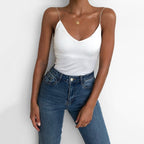 Lifestyle shot of a white satin camisole top with thin straps and v-neckline, chic minimalist style.