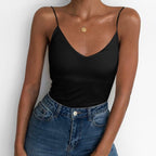 Lifestyle view of a fitted black satin camisole top with thin straps and v-neckline, sophisticated minimalist style.