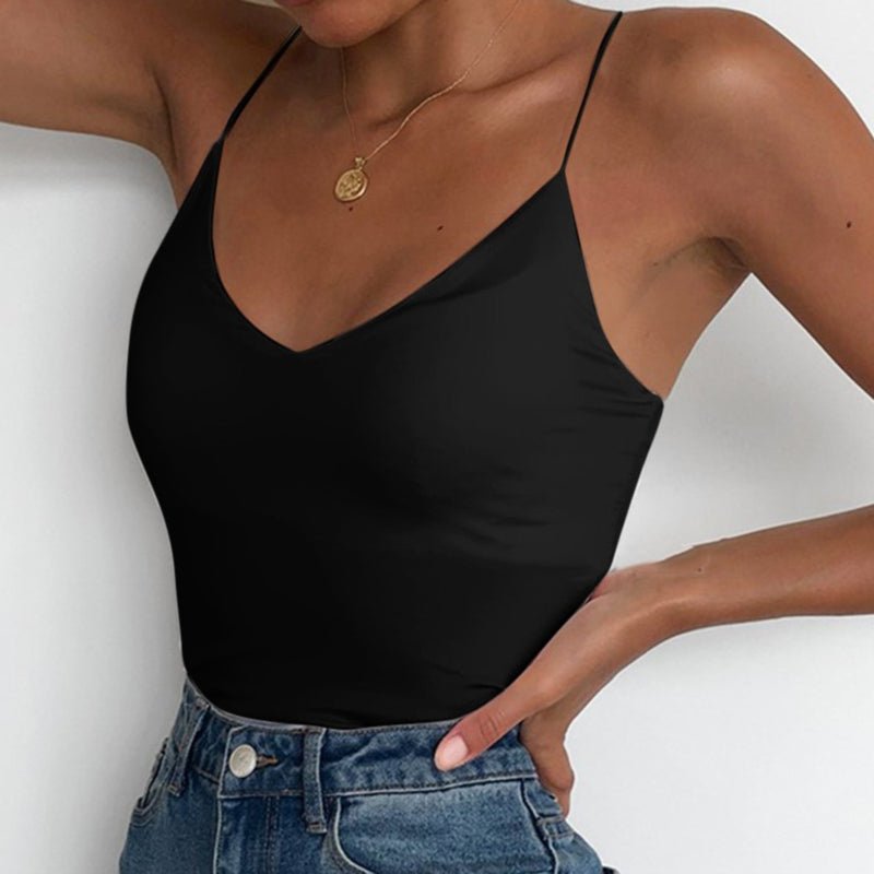 Lifestyle shot of a white satin camisole top with thin straps and v-neckline, perfect for a capsule wardrobe.