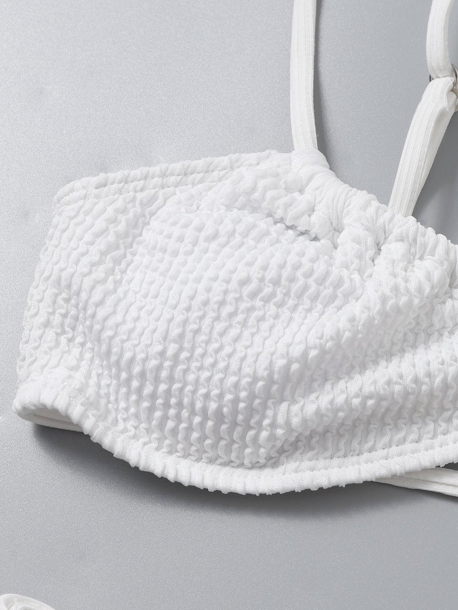 Detail close-up of a white bikini top highlighting padded cups and soft fabric, perfect for a minimalist swimwear collection.