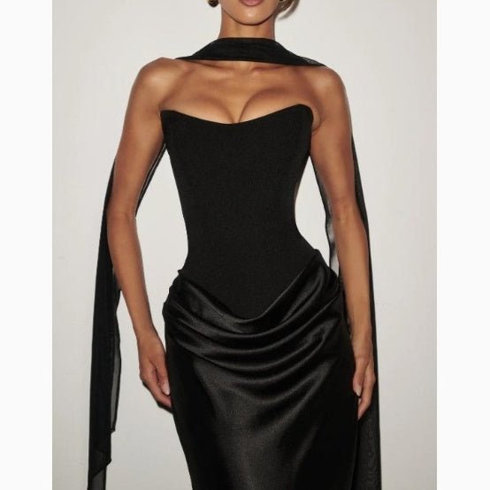 Detail close-up of the black off-shoulder dress, featuring a v-neck and elegant ribbon accents.