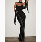 Back view of the black off-shoulder dress, highlighting its figure-hugging silhouette and ribbon details.