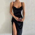 Front view of a black midi dress with suspender straps and a front slit, elegant minimalist design