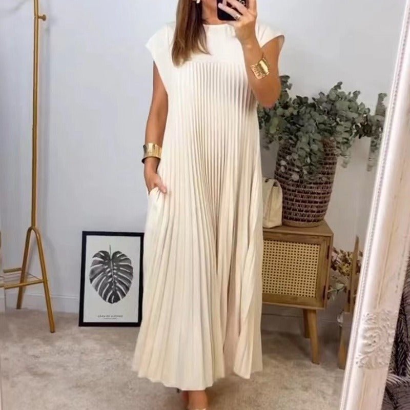 Beige pleated long dress with cap sleeves, set against a natural backdrop, showcasing chic design.
