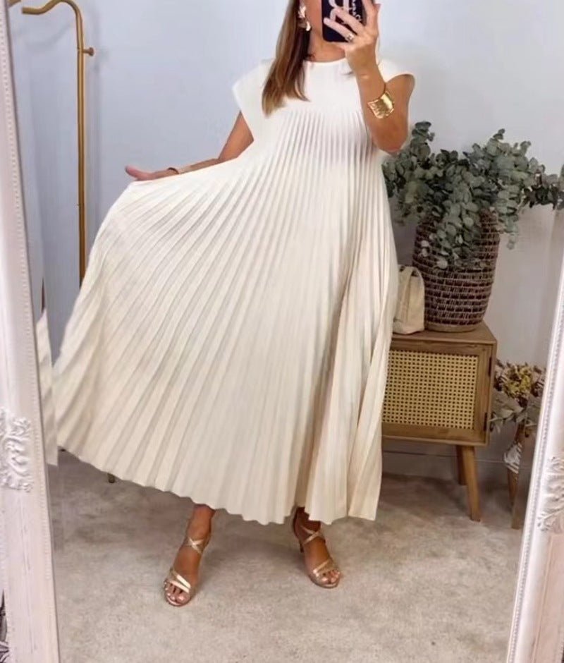 Beige pleated long dress featuring cap sleeves, elegantly displayed in a natural background.
