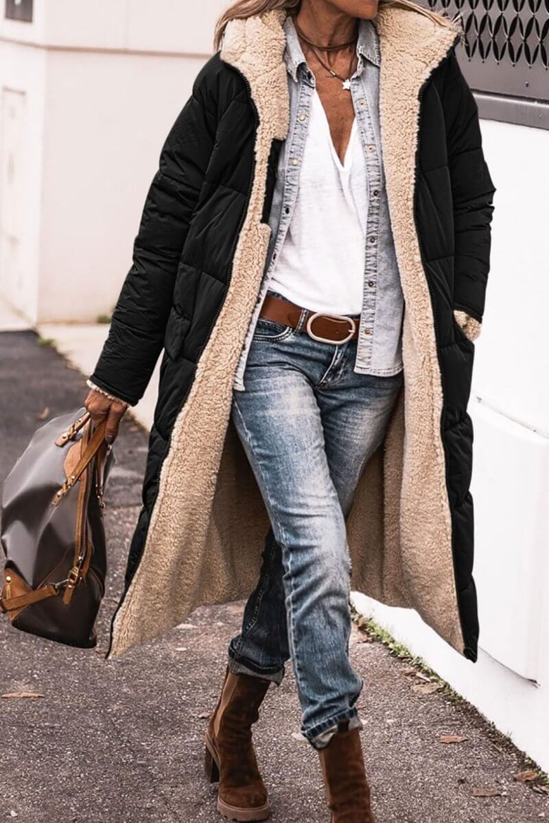 Black hooded long coat with zipper closure, featuring a slim fit and long sleeves in a lifestyle setting.