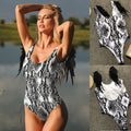 Lifestyle shot of a black and white snake print swimsuit bodysuit, showcasing a deep V-neck and chic minimalist style.