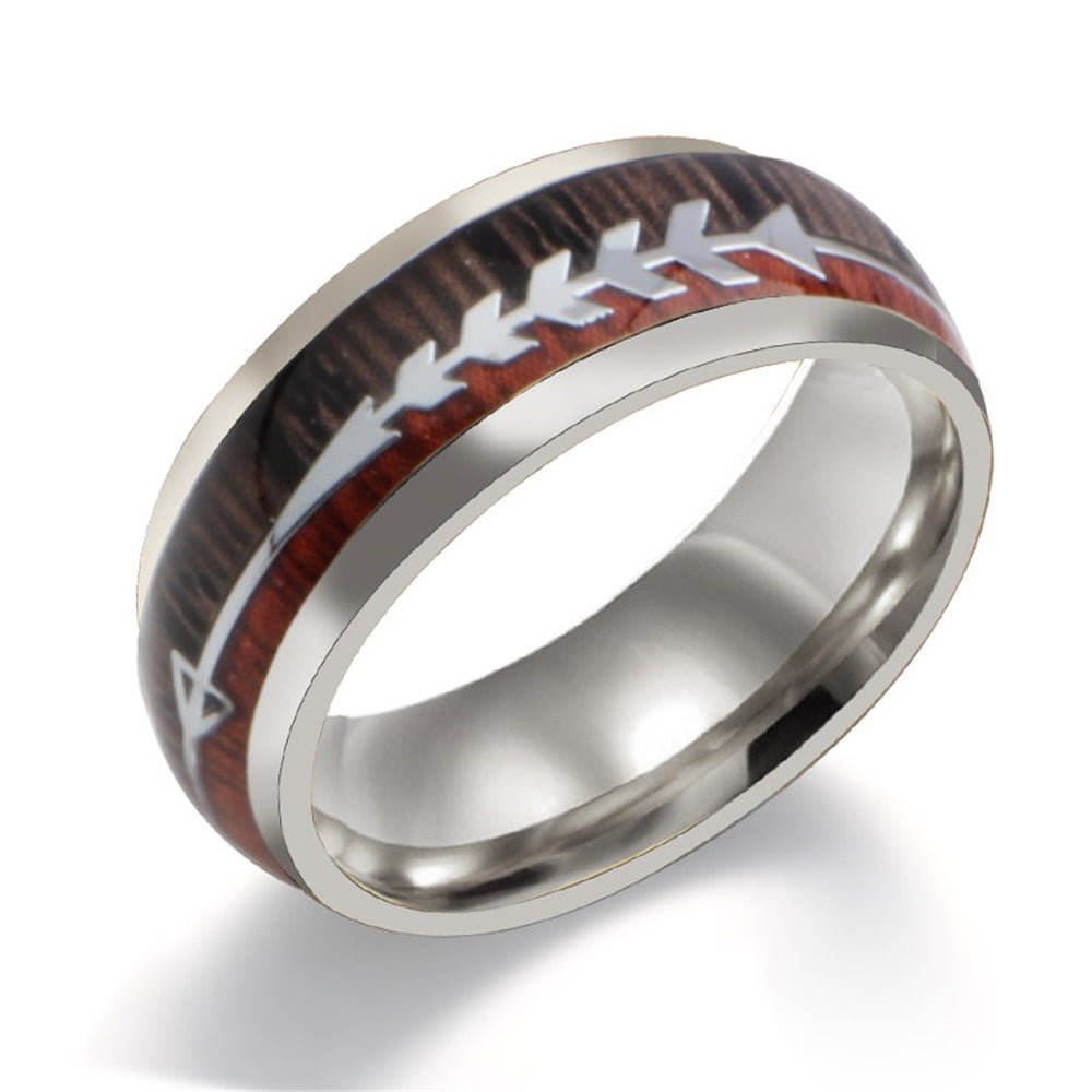 Men's stainless steel ring with smooth finish and arrow inlay in black, rose gold, and silver, detail close-up.