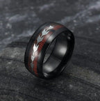 Men's stainless steel ring with smooth finish and arrow inlay in rose gold and black, detail close-up.