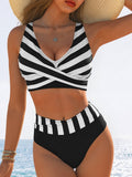 Lifestyle shot of a sexy black and white striped high-waist bikini with cross-over detailing.