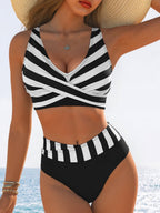 Lifestyle shot of a sexy black and white striped high-waist bikini with cross-over detailing.