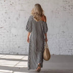 Back view of a gray and white striped off-shoulder maxi dress, emphasizing the striped pattern.