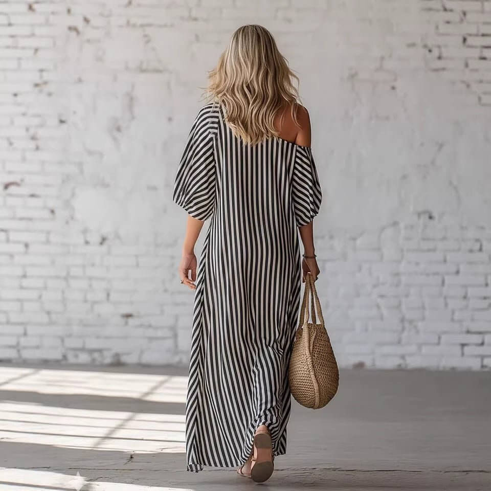 Back view of a gray and white striped off-shoulder maxi dress, emphasizing the striped pattern.