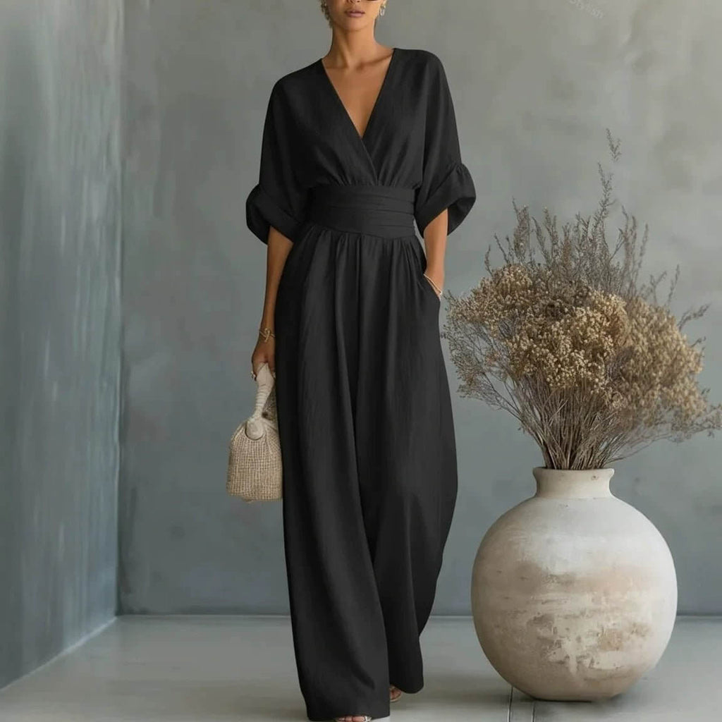 Lifestyle shot of a black wide-leg jumpsuit featuring v-neck and pockets, elegant minimalist style.