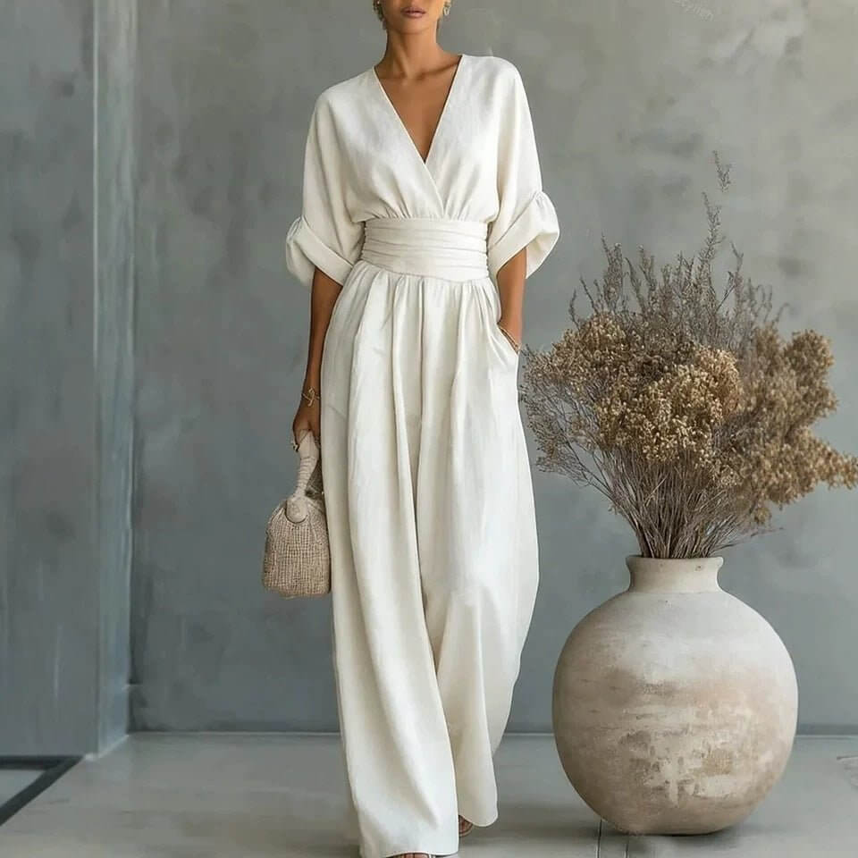 Lifestyle shot of a white wide-leg jumpsuit with v-neck and pockets, chic minimalist fashion.