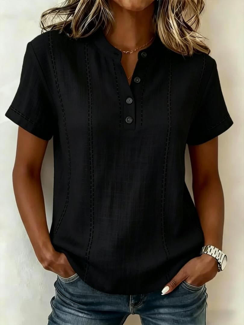 Front view of the black short sleeve blouse showcasing a v-neck and rolled sleeves, elegant minimalist design.