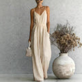 Lifestyle shot of a beige wide-leg jumpsuit featuring spaghetti straps and pockets, elegant casual look @Black#White