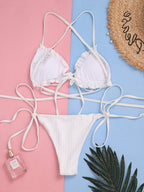 Detail shot of a white triangle bikini top with pleated design and adjustable ties.