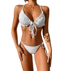 Front view of a white bikini with ruffled edges and tie straps, emphasizing the chic design.