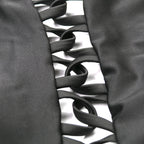Close-up detail of black spandex bikini with ribbon detailing, showcasing its smooth texture.