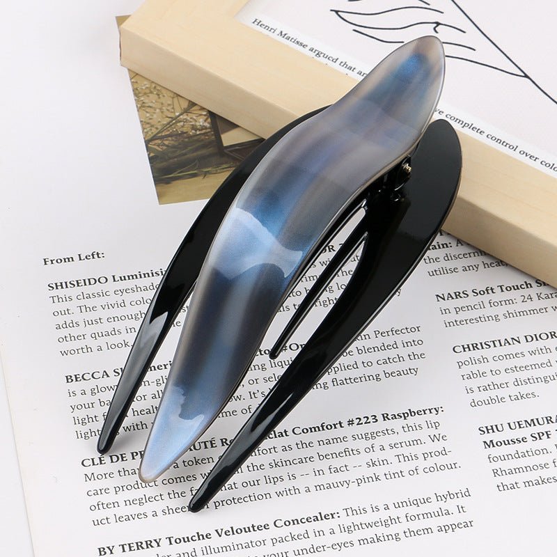 Detail close-up of black and blue acetate hairpin, showcasing its unique design and chic appeal.