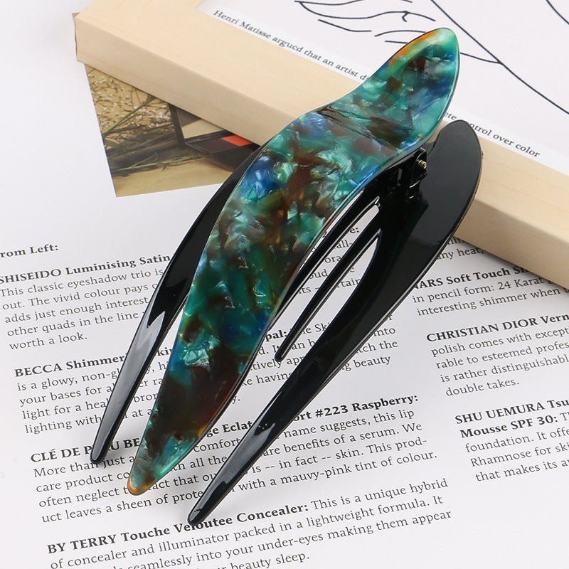 Detail close-up of colorful blue acetate hairpin, featuring vibrant colors and a sleek design.