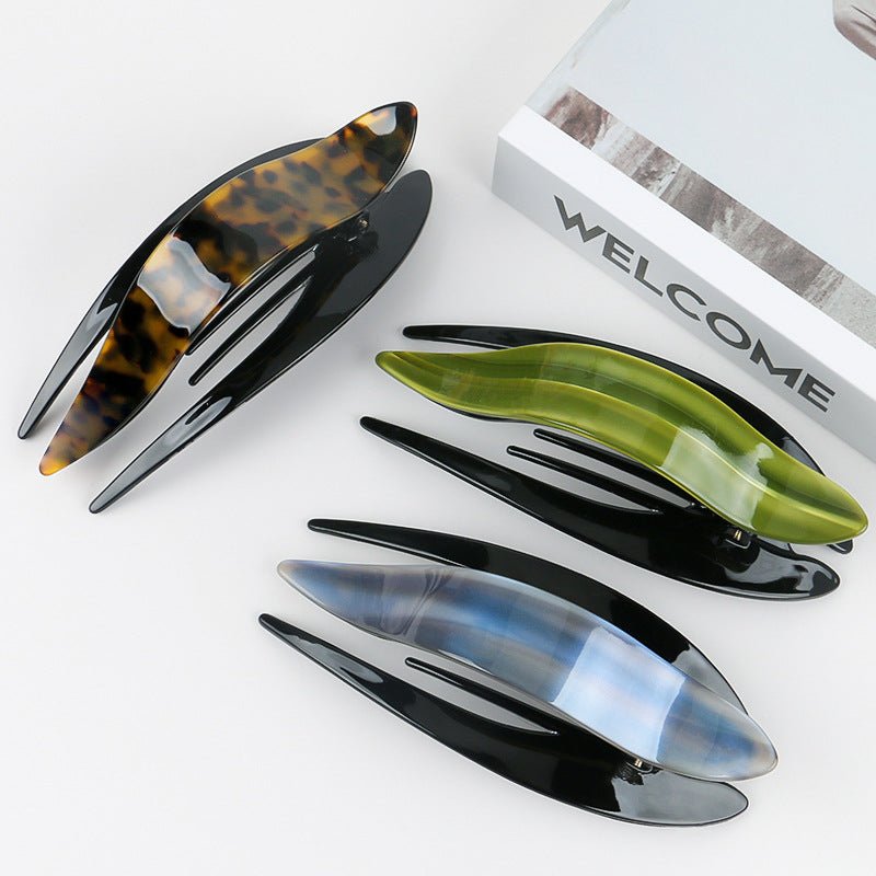 Detail close-up of an elegant acetate hairpin in tortoise shell, emphasizing its stylish design.